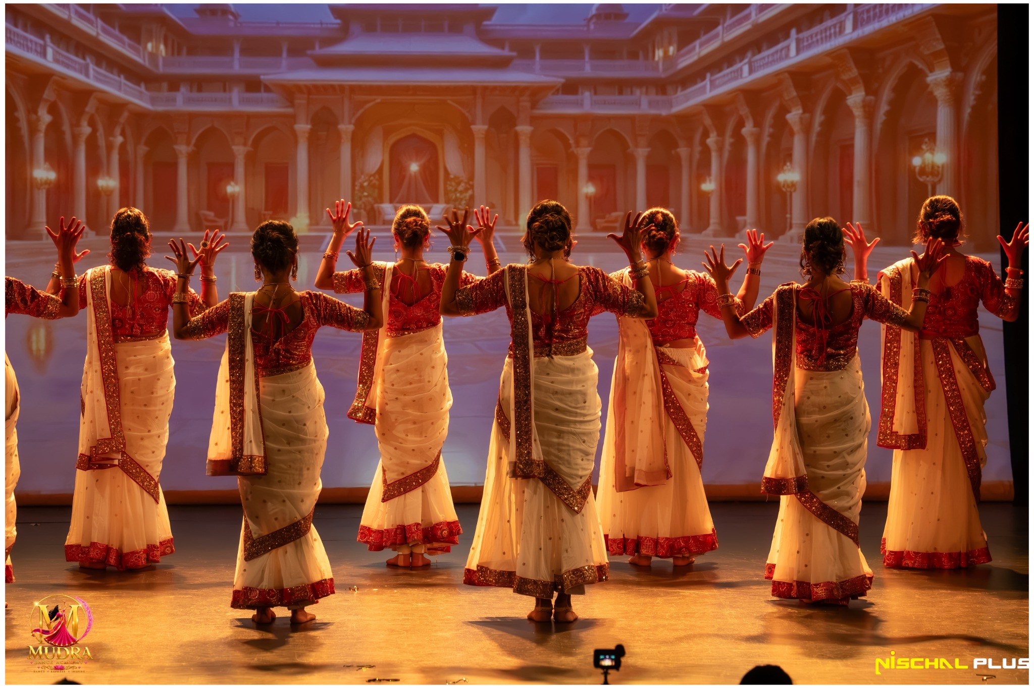 Mudra Dance Academy dancers performing in white and red classical costumes