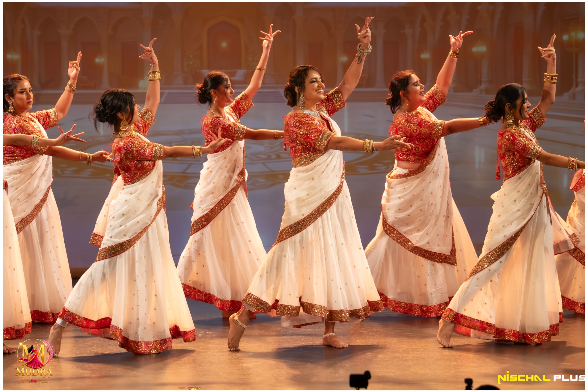 Mudra Dance Academy dancers creating a graceful formation in white costumes