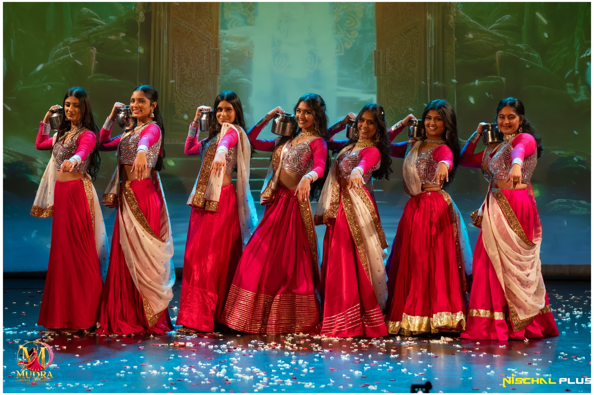 Mudra Dance Academy dancers performing together in red and pink costumes