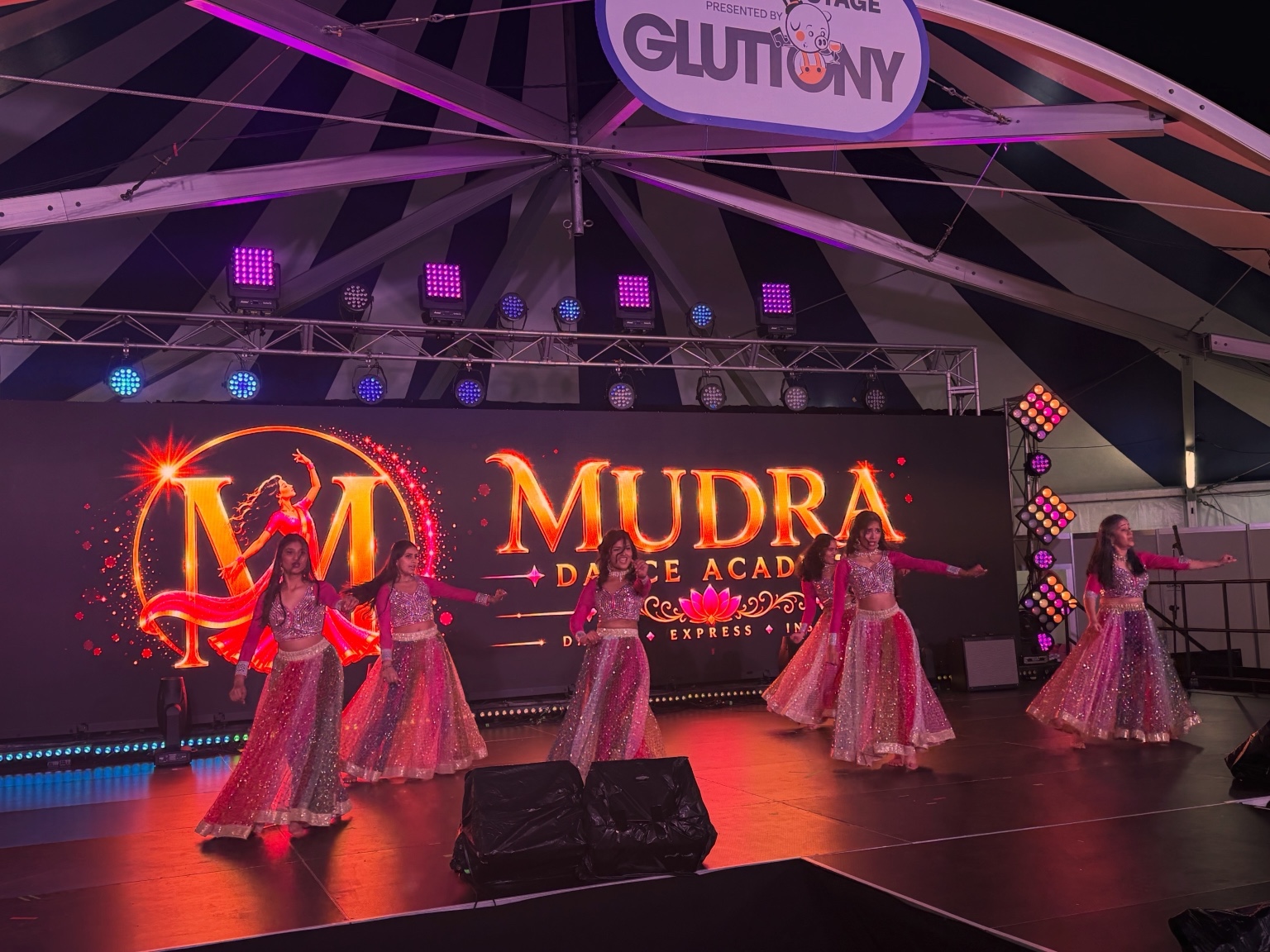 Mudra Dance Academy dancers in pink costumes performing before the academy backdrop at the Royal Adelaide Show